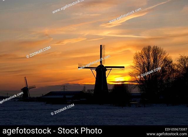 Silhouettes of two windmills at sunset near the Dutch village Bleskensgraaf