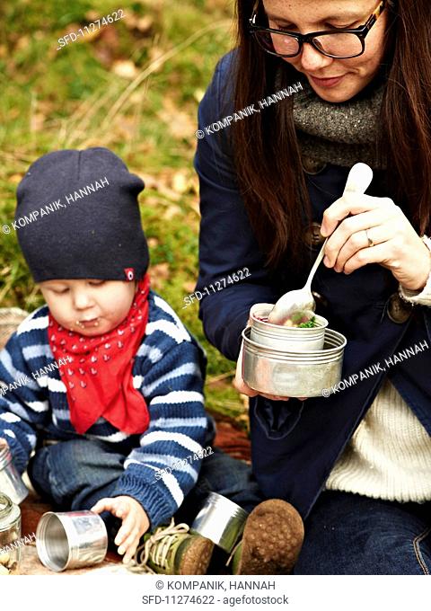 A woman and a child eating beetroot soup at an autumnal picnic