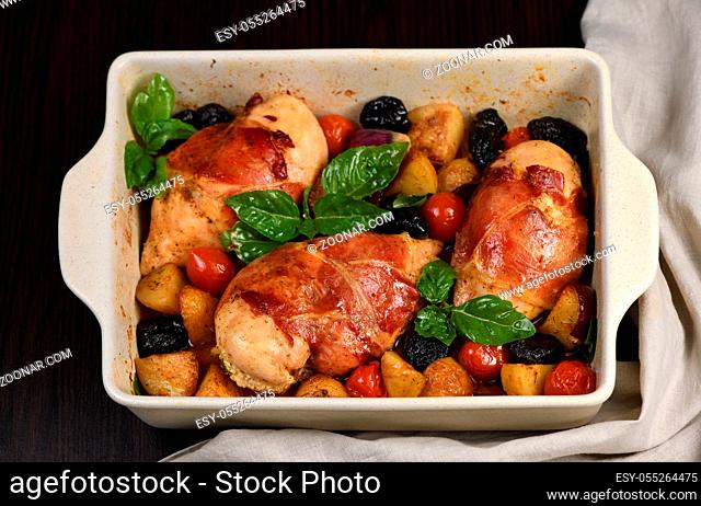 Chicken breast stuffed with goat cheese with spinach, wrapped in prosciutto, with slices of baked potatoes, tomatoes, and dried prunes