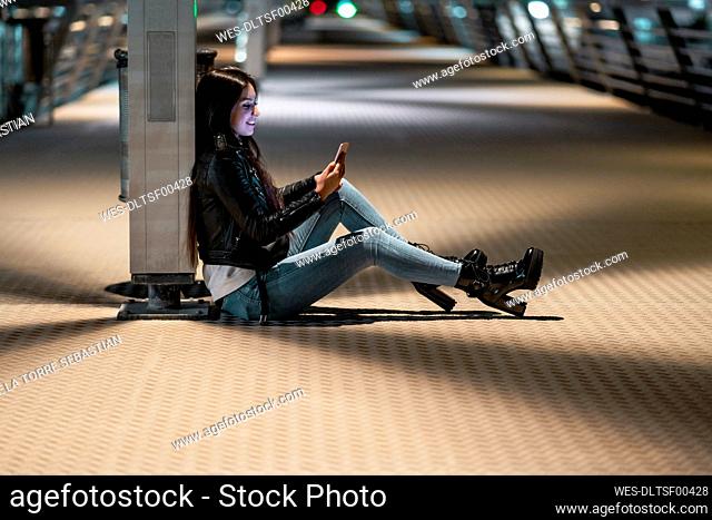 Teenage girl using smartphone at night