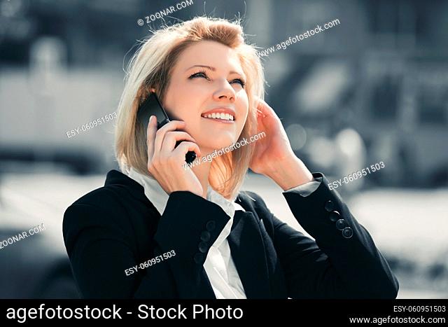 Young fashion business woman calling on mobile phone in a city street