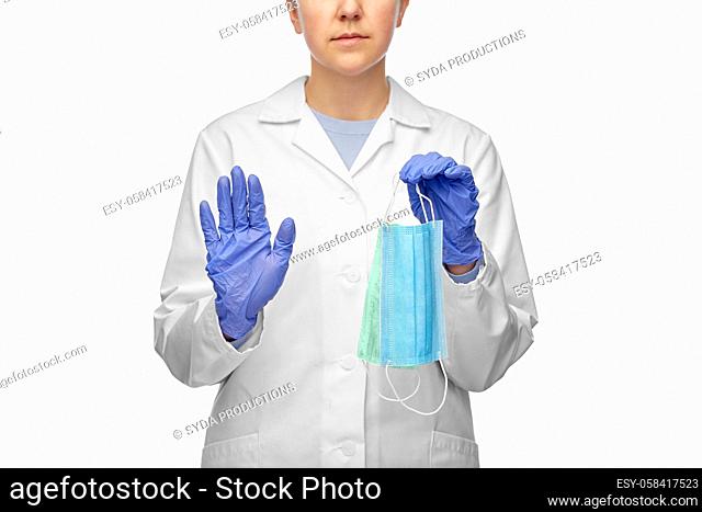 female doctor with two masks showing stop gesture