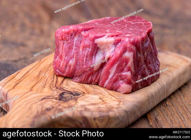 rohes Steak auf dunklem Holz