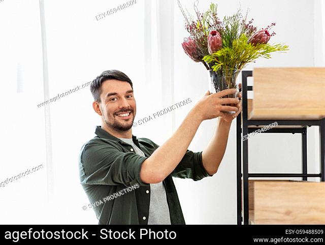 man decorating home with flower or houseplant
