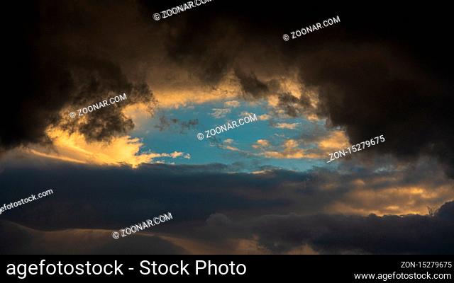 Dramatic clouds illuminated rising of sun floating in sky. Natural weather, meteorology background. Heavenly landscape image ready for design