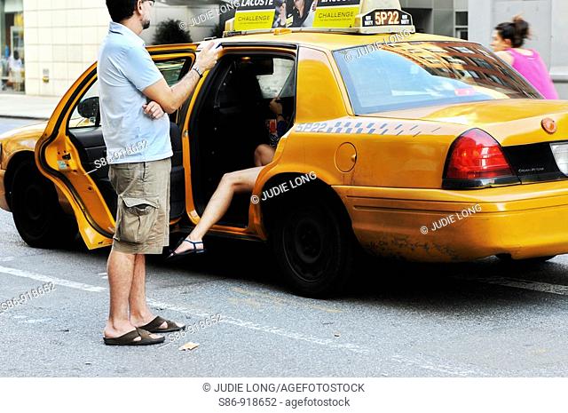 Shapley legs of a woman exiting a NYC taxi, man admiringly watching