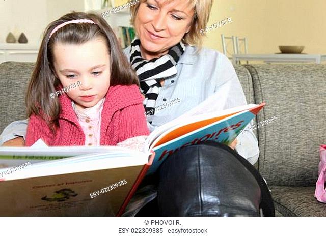 Grandmother reading a story to her granddaughter
