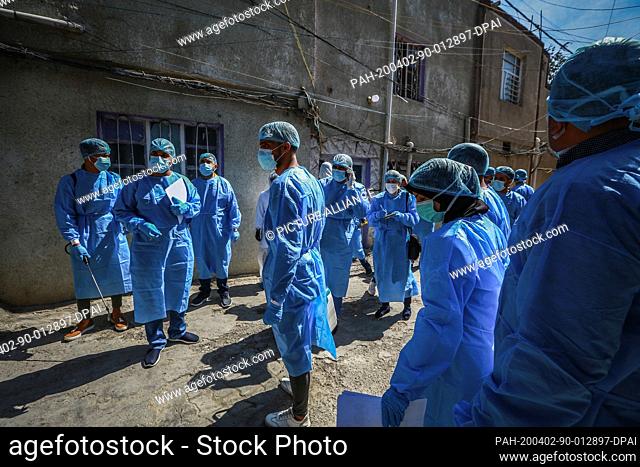02 April 2020, Iraq, Baghdad: Medics take part in a campaign held by the Iraqi Ministry of Health to test people at Sadr City, a suburb district of Baghdad