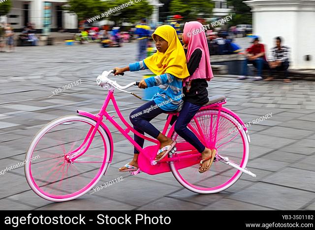 Indonesian Children Cycling In Taman Fatahillah Square, Jakarta, Indonesia