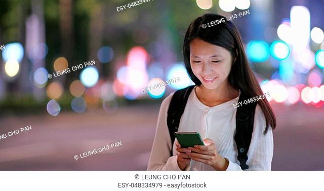 Woman use of smart phone in the city at night