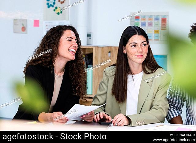 Happy businesswoman holding document in office