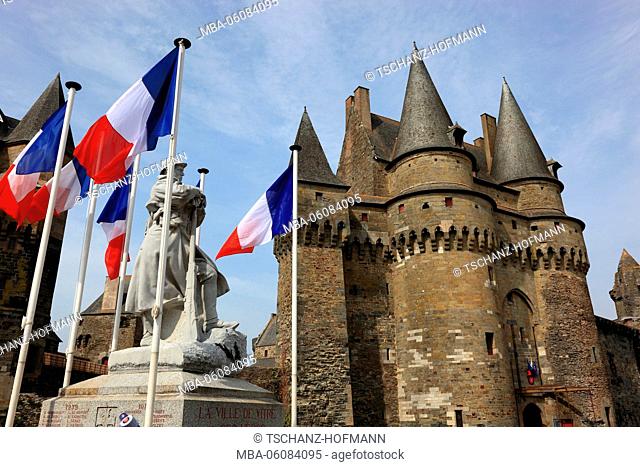 France, region of Brittany, the medieval Château de Vitré (castle) in front of it a war memorial and flags