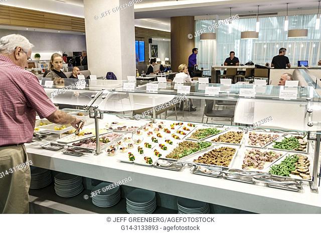 Florida, Miami, International Airport MIA, terminal concourse gate area, American Airlines business class Flagship lounge, dining room, buffet, food, trays, man