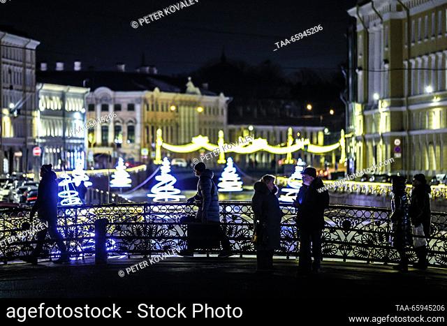 RUSSIA, ST PETERSBURG - DECEMBER 20, 2023: Citizens cross Pevchesky Bridge as Christmas lights line up along the Moika River. Peter Kovalev/TASS