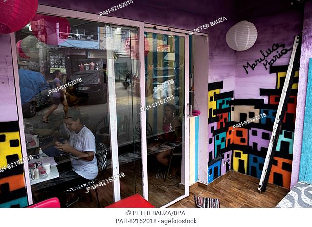 A barber shop with painted walls by peace activist MarieLuce in the favela Complexo do Alemão in Rio de Janeiro, Brazil, 16 July 2016
