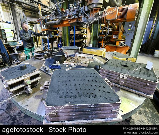 05 April 2022, Saxony, Leipzig: In the molding shop of the Keßler & Co GmbH foundry, a foundry mechanic fills quartz sand with resin and hardener into mold...