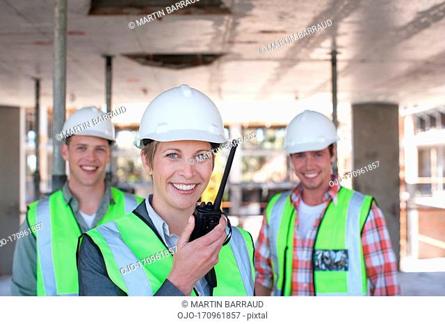 Construction worker holding walkie talkie on construction site