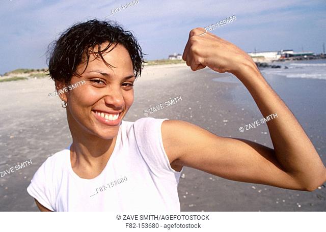 Young woman flexing muscles