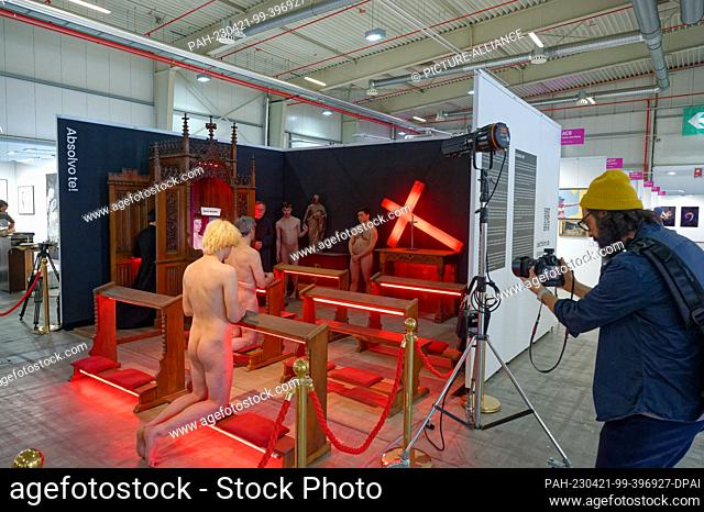 dpatop - PRODUCTION - 20 April 2023, North Rhine-Westphalia, Cologne: Naked men and two men in black gowns act in an art action