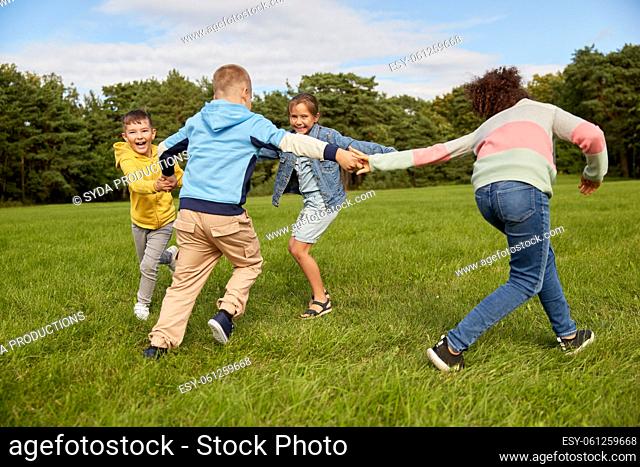 happy children playing round dance at park
