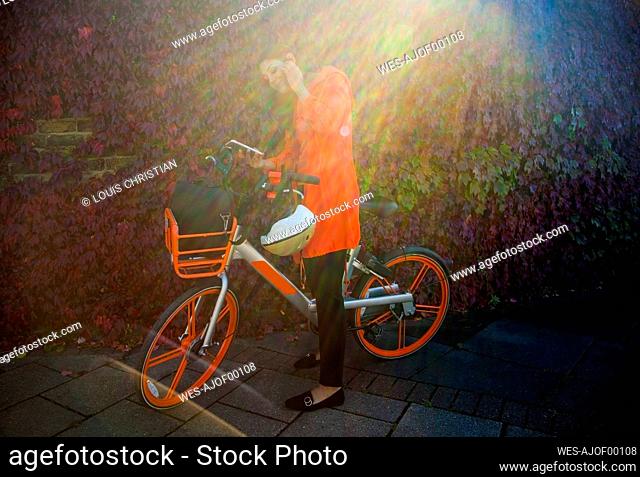 Young woman activating rental bike with smartphone app