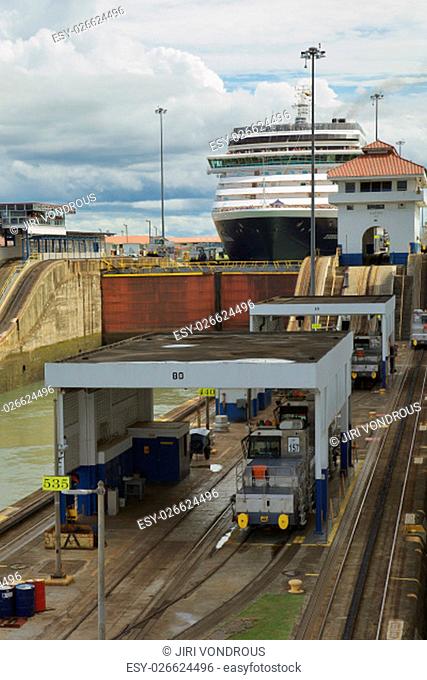 Cruise ship going through locks in Panama Canal. Vertical image with cloudy sky in the background