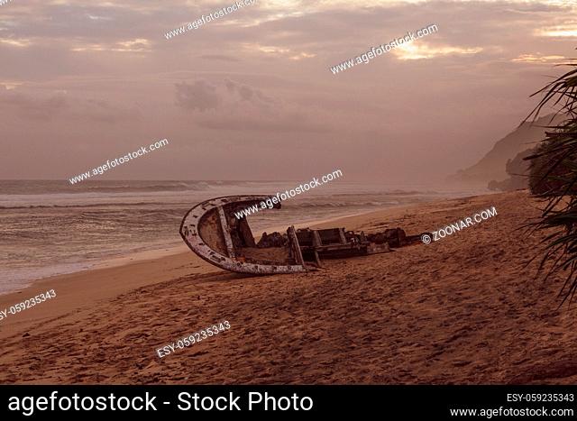 Shipwreck at the sandy beach in Bali during amazing sunset, Indonesia