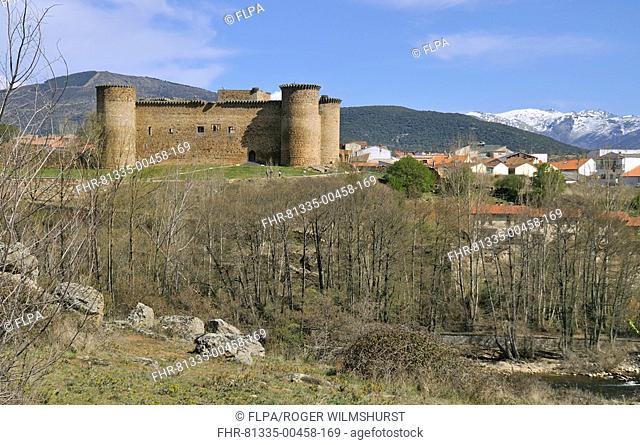 View of town and Roman castle, snow-capped mountains in distance, El Barco, Gredos Mountains, Castilla y Leon, Spain, april