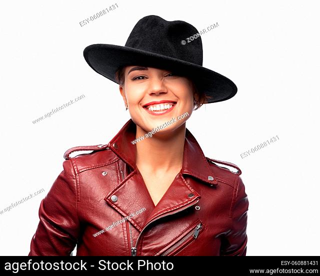Beautiful laughing woman wearing a leather jacket and a black hat on a white background is isolated. Clipping path included