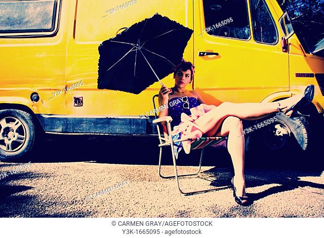 Fashion picture of a girl with an umbrella, from a whole series with a yellow van