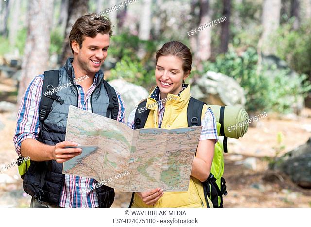 Young couple planning with map while hiking