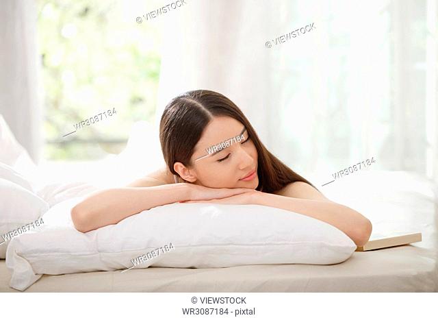 Young women lie on the bed