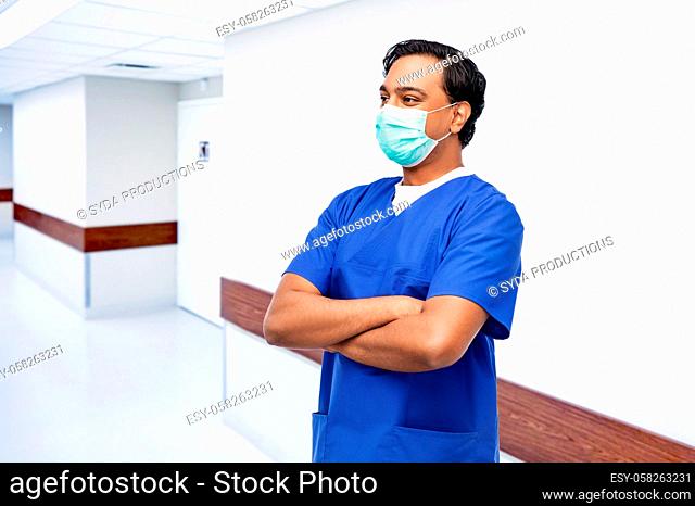 indian male doctor in blue uniform and mask