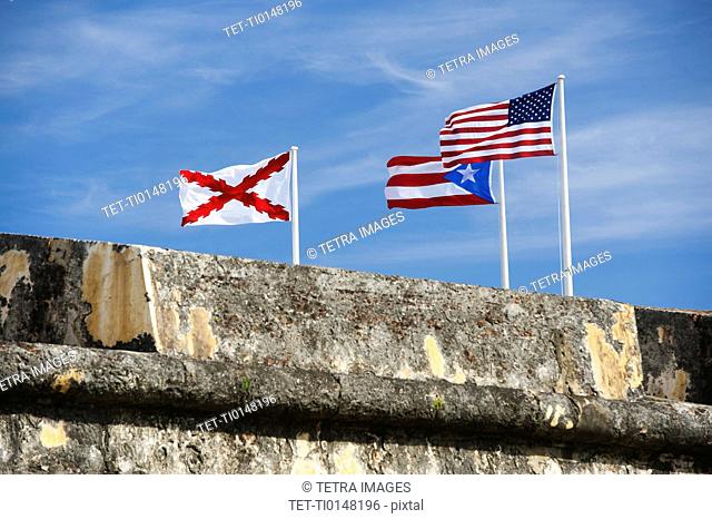 Puerto Rico, Old San Juan, El Morro Fortress, flags behind wall