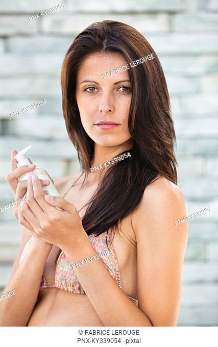 Portrait of a woman holding sanitizer bottle