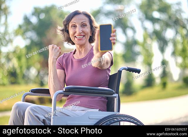 Happy day. A woman on wheel-chair looking excited and feeling happy