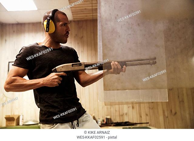 Man shooting with a rifle in an indoor shooting range