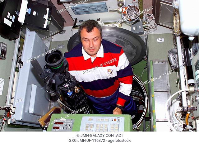 Vladimir N. Dezhurov of Rosaviakosmos, Expedition Three flight engineer, enters the Zvezda Service Module carrying a high definition camera during the initial...