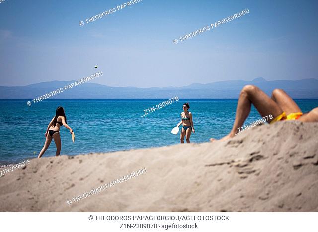 Two girls playing rackets on Santova beach. Kalamata, Messenia, Peloponnese, Greece