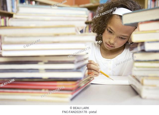Schoolgirl behind stacks of books