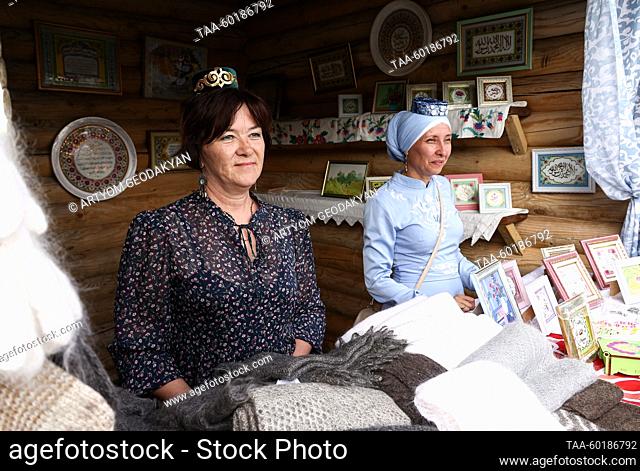 RUSSIA, MOSCOW - JULY 1, 2023: Vendors in a stall selling woolen shawls and picture frames during Sabantuy 2023, a citywide festival at the Kolomenskoye Museum...