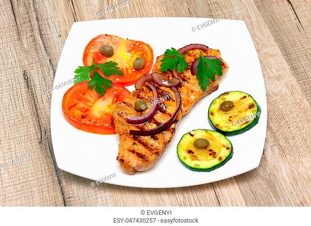 grilled meat with vegetables on a wooden background. horizontal photo
