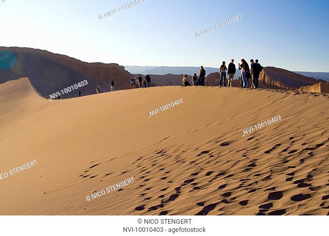 Tourists standing on a dune in the Valle de la Luna, San Pedro de Atacama, Chile, South America