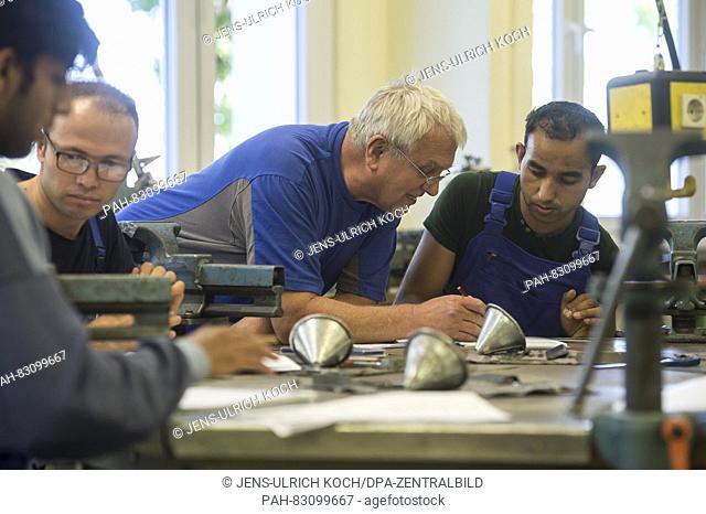 Trainer for metal working, Waldemar Balakin (m), talks to young refugees from Afghanistan at the education centre of the international association (IB) in Jena