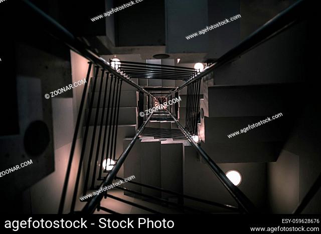 Abstract architectural image with a modern staircase on many levels, viewed from down to up, with artificial low light, in Karlsruhe, Germany