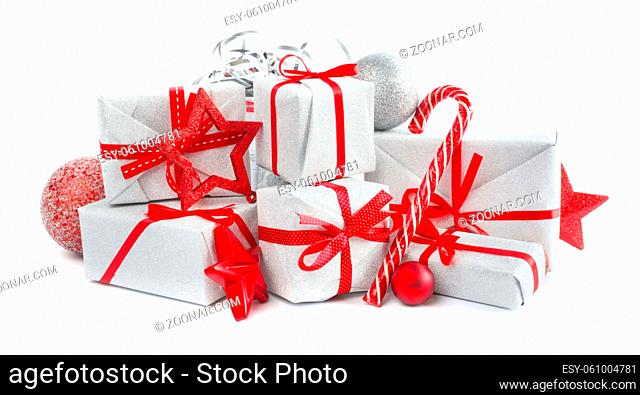 Heap of similar Christmas silver gift boxes with red ribbon decor stars baubles and candy cane isolated on white background