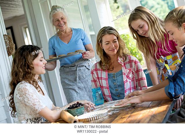Farmhouse in the country in New York State. Four generations of women in a family baking cookies and apple pie