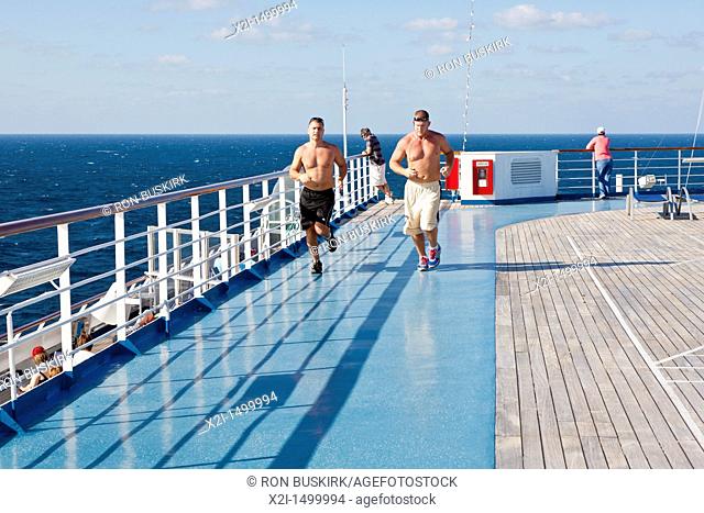 Two men running on jogging track on the sports deck of Carnival's Triumph cruise ship in the Gulf of Mexico