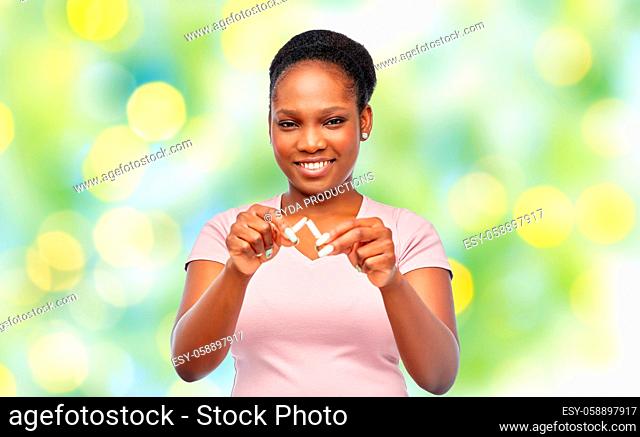 smiling african american woman braking cigarette