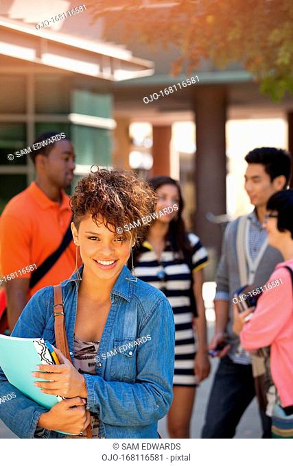 Smiling student carrying folder